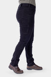 Side view of a woman wearing Dovetail Workwear's Maven X Graphene Denim Pant in black, showcasing the hip slot and slim-leg fit with brown boots
