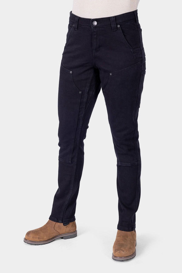 Black Maven X Graphene Denim Pant by Dovetail Workwear shown on a woman, featuring reinforced pockets, crotch gusset, and slim-leg carpenter styling with tan boots