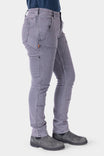 Side view of a woman wearing Dovetail Workwear's Maven X HOTSWAP™ Thermal Denim Pant in grey, showcasing the slim fit, Hip Slot™ pockets, and reinforced crotch gusset design