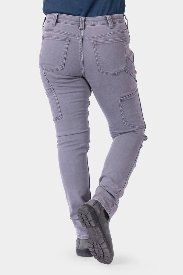Back view of a woman wearing Dovetail Workwear's Maven X HOTSWAP™ Thermal Denim Pant in grey, showcasing Hip Slot™ pockets, reinforced stitching, and slim fit design