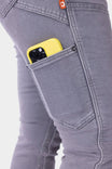 Detail shot of a woman's thigh wearing grey Maven X HOTSWAP™ Thermal Denim Pant by Dovetail Workwear, with a yellow phone visible in the front Hip Slot™ pocket