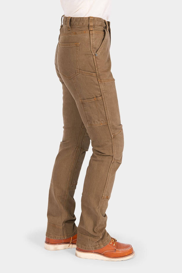Side view of a woman wearing Dovetail Workwear's Old School High Rise Work Pant in Beechwood Brown, featuring Hip Slot™ Zip pocket, tool loop, knee pad slot, and a straight-leg silhouette