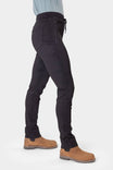 Side view of a woman wearing Dovetail Workwear's Christa X DIY Pant in Black Performance Modal, featuring visible side pockets, tool loop, and reinforced knees