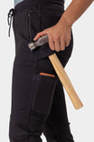 Woman holding a hammer while wearing the Christa X DIY Pant in Black Performance Modal by Dovetail Workwear, showcasing the tool loop and front zip pocket details