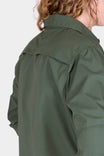 Back view of a woman wearing the Aventurine Green AJ COOLSWAP™ Work Shirt by Dovetail Workwear, highlighting the back yoke vent and ripstop fabric construction