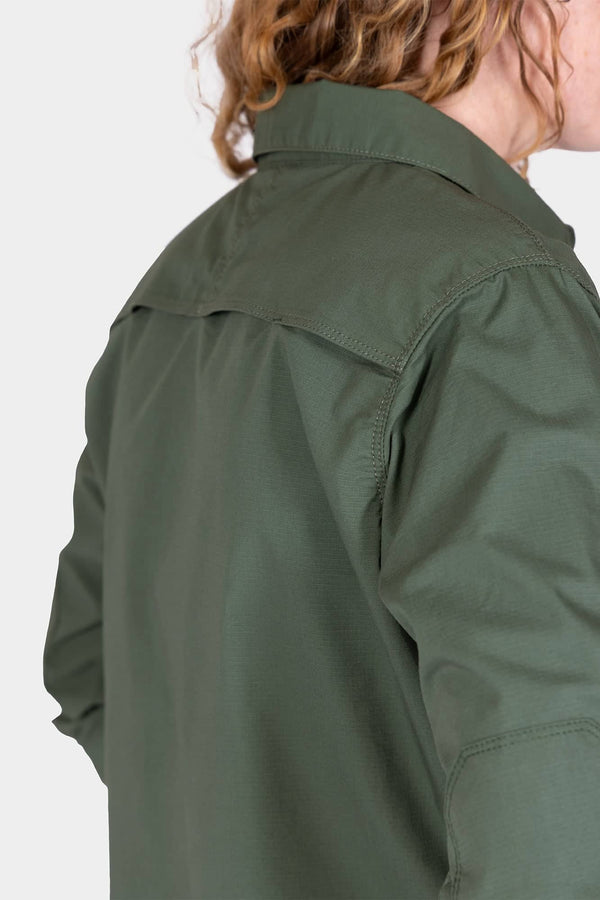 Back view of a woman wearing the Aventurine Green AJ COOLSWAP™ Work Shirt by Dovetail Workwear, highlighting the back yoke vent and ripstop fabric construction