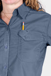 Detail view of the AJ COOLSWAP™ Work Shirt in Dovetail Blue, showing the buttoned chest pocket and pencil holder with a woman wearing a gold chain necklace