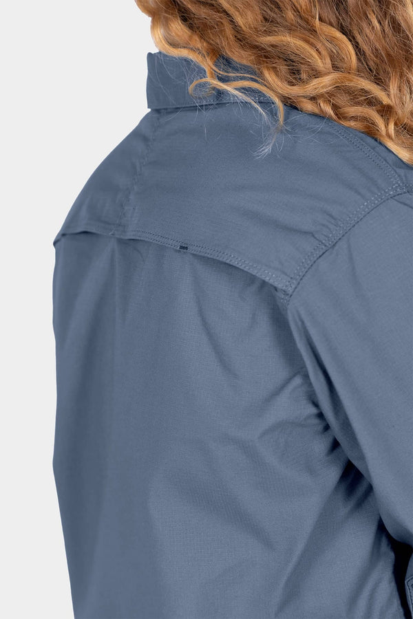 Back view of a woman wearing the Dovetail Workwear AJ COOLSWAP™ Work Shirt in Dovetail Blue, showing the back yoke vent and ripstop fabric construction