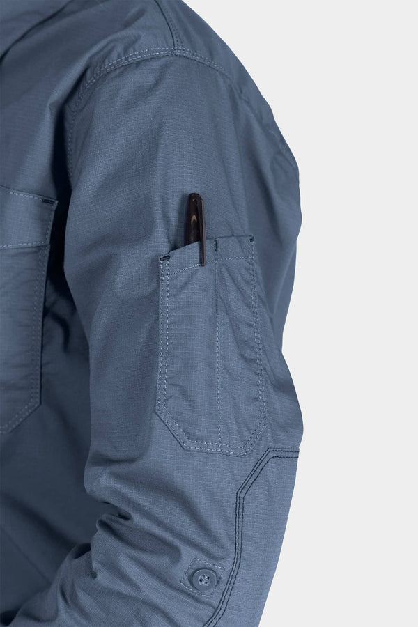 Detail shot of the AJ COOLSWAP™ Work Shirt in Dovetail Blue, highlighting the buttoned chest pocket and armpit vent for breathability