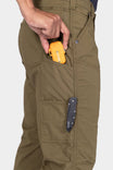 Detail shot of a woman's cargo pocket on the Dovetail Workwear Anna Ultralight Trail Pant in Kelp Green Ripstop, displaying the Hip Slot™ tool loop with a yellow multi-tool and nested pocket storage