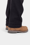 Close-up detail of the cuff and hem of Dovetail Workwear's Britt Utility Pant in No Fade Black Canvas, showing reinforced construction and tough cuff paired with tan work boots