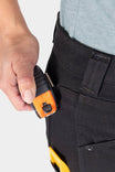 Close-up of a woman's hand accessing the tool loop on the Britt Utility Pant in No Fade Black Canvas, showcasing the functional design detail