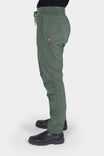 Side view of a woman wearing the Aventurine Green Christa X DIY COOLSWAP™ Pant by Dovetail Workwear, showing multiple pockets and slim leg design.