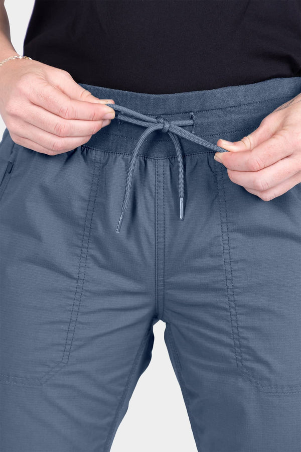 Detail shot of a woman adjusting the drawcord on the Christa X DIY COOLSWAP™ Pant in Dovetail Blue, showing the EZWaist™ stretch waistband