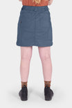 Back view of a woman wearing the Dovetail Workwear Compass COOLSWAP™ Cargo Skort in Dovetail Blue, showcasing the deep inset back pockets and high-rise waistband