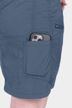 Detail of the Dovetail Blue Compass COOLSWAP™ Cargo Skort showing a woman with a smartphone in the functional phone pocket on the thigh