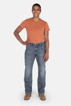 Woman wearing Dovetail Workwear's Day Construct Work Pant in Vintage Blue denim with an orange t-shirt, standing with hand on hip