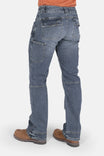 Back view of a woman wearing Dovetail Workwear's Day Construct Work Pant in Vintage Blue vintage stretch denim, showing reinforced pockets, crotch gusset, and knee pad slot