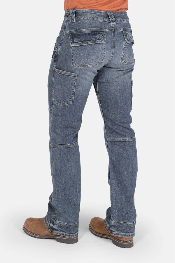 Back view of a woman wearing Dovetail Workwear's Day Construct Work Pant in Vintage Blue vintage stretch denim, showing reinforced pockets, crotch gusset, and knee pad slot