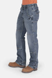 Side view of a woman wearing Dovetail Workwear's Day Construct Work Pant in Vintage Blue denim, featuring reinforced front pockets, reinforced knees, and a relaxed straight leg silhouette