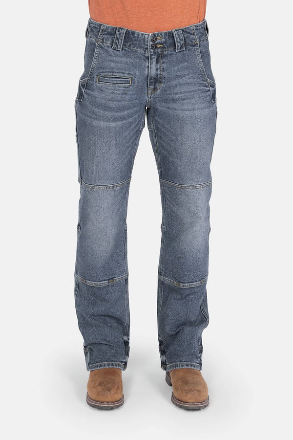 Front view of a woman wearing Dovetail Workwear's Day Construct Work Pant in Vintage Blue denim, featuring a mid-rise waist, reinforced pockets, crotch gusset, and knee pad slot