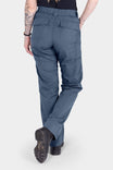 Back view of a woman wearing the Dovetail Workwear Day X COOLSWAP™ Pant in Dovetail Blue, featuring nested side pockets and a relaxed straight leg fit over work boots