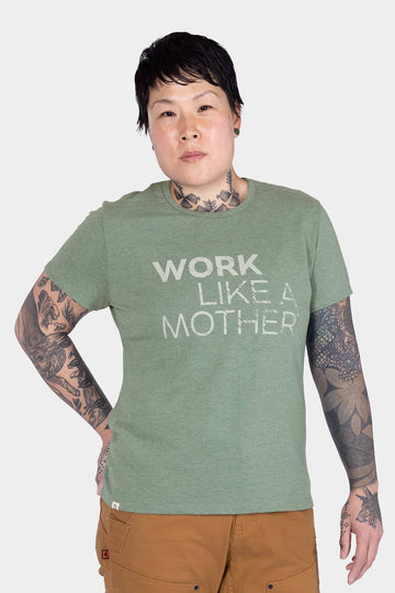 Dovetail Workwear GO TO™ "Work Like a Mother" Graphic Work Tee in sage green, worn by a woman with visible arm tattoos and brown pants