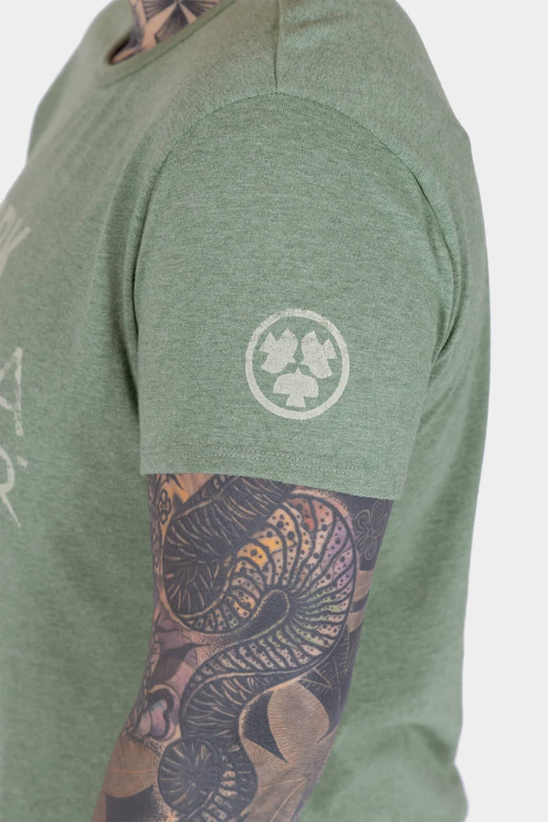 Side view of a woman wearing the Dovetail Workwear GO TO "Work Like a Mother" Graphic Work Tee in sage green with front graphic