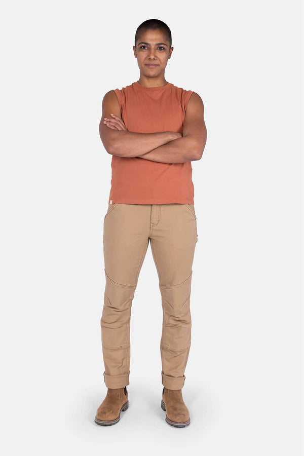 Terracotta GO TO™ Tank Top by Dovetail Workwear worn by a woman with arms crossed, paired with khaki work pants and boots