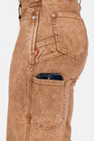 Side view of a woman wearing Dovetail Workwear's Old School Wide Leg Mineral Wash Jeans in Sunbaked Copper, highlighting the nested side pockets and phone pocket with a smartphone visible