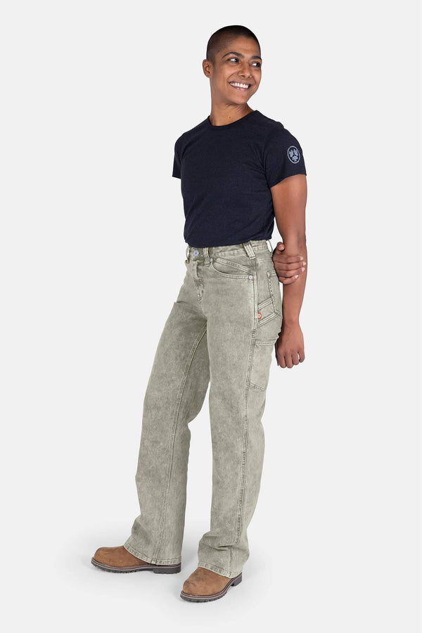 Side view of a woman wearing Dovetail Workwear's Old School Wide Leg Mineral Wash Jeans in Sunbaked Copper with a navy tee and brown boots
