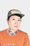 Dovetail Workwear Pack Cap in Desert Tan worn by a woman, showcasing the 5-panel construction, adjustable back closure, and breathable design of this classic work cap
