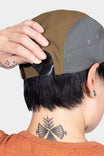 Back view of a woman wearing the Desert Tan Pack Cap, showing the adjustable back closure and side ventilation ports