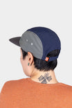 Back view of a woman wearing the Ocean Blue Pack Cap, showing the adjustable back closure and side ventilation ports