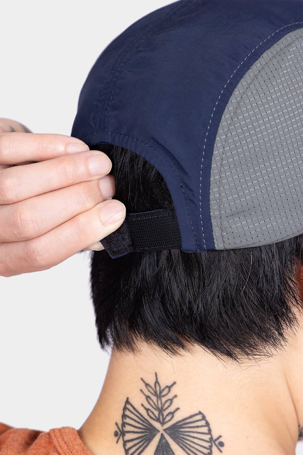 Back view of a woman wearing the Ocean Blue Pack Cap, showing the adjustable back closure and side ventilation ports for breathability