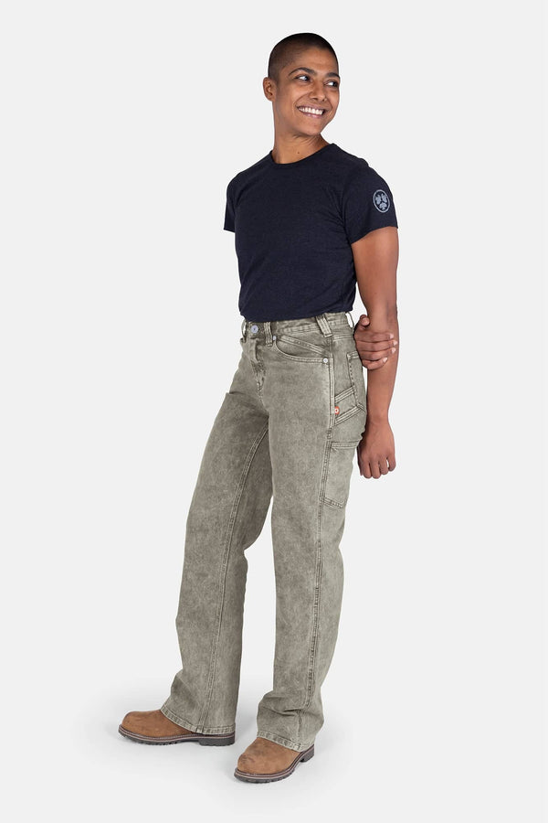 Side view of a woman wearing Dovetail Workwear's Old School Wide Leg Mineral Wash Jeans in Sunbaked Eucalyptus with a navy t-shirt and brown boots
