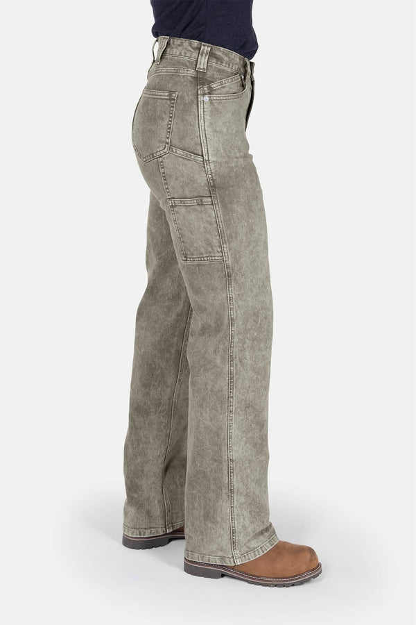 Side view of a woman wearing Dovetail Workwear's Old School Wide Leg Mineral Wash Jeans in Sunbaked Eucalyptus, featuring nested side pockets and a high-rise fit