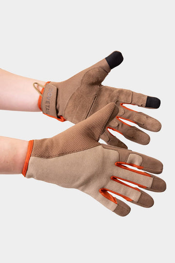 Detail shot of Dovetail Workwear Multi-Purpose Work Gloves in Light Kodiak, displaying touchscreen-compatible fingers, leather reinforcements, and adjustable wrist straps on a woman's hands