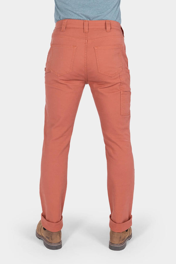 Back view of a woman wearing Dovetail Workwear GO TO™ Pants in Terracotta, showing reinforced knee, tool loop, and rolled cuffs