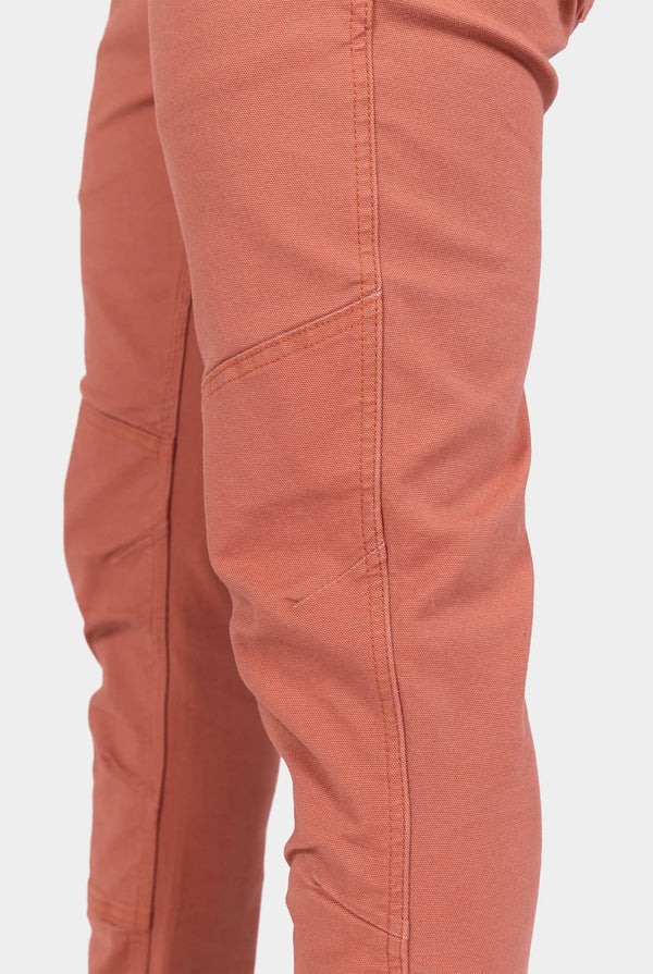 Side view of a woman wearing Dovetail Workwear GO TO™ Pants in Terracotta, highlighting the articulated knee and reinforced knee design in stretch canvas.
