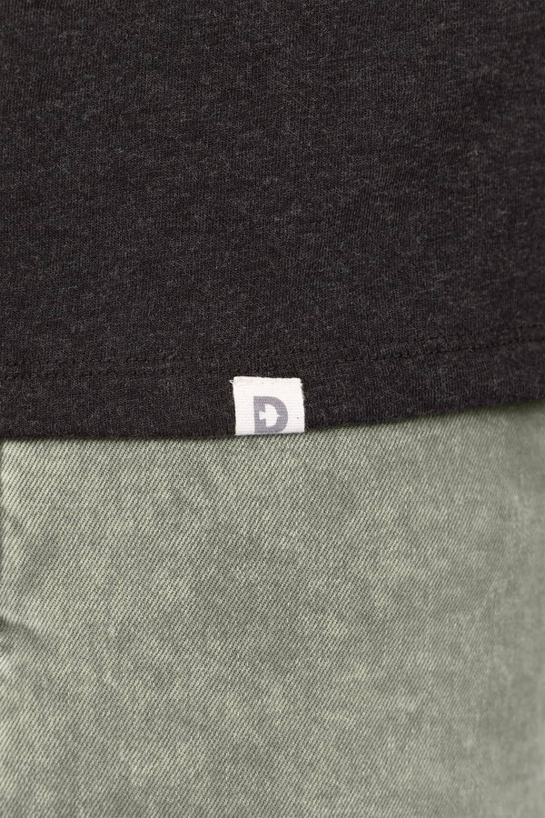 Detail shot of the Dovetail Workwear GO TO™ Crew Neck Tee Shirt showing the brand label at the seam between Black and Agave Green fabric