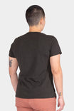 Back view of a woman wearing the Dovetail Workwear GO TO "Woman Up" Graphic Work Tee in charcoal, showcasing the relaxed fit and cotton jersey blend fabric