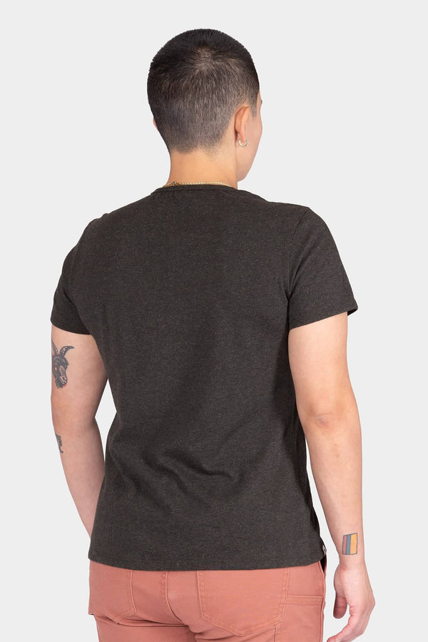 Back view of a woman wearing the Dovetail Workwear GO TO "Woman Up" Graphic Work Tee in charcoal, showcasing the relaxed fit and cotton jersey blend fabric