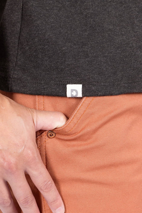 Close-up detail of the Dovetail Workwear GO TO™ "Woman Up" Graphic Work Tee in charcoal, showing the soft cotton jersey blend fabric and relaxed fit on a woman