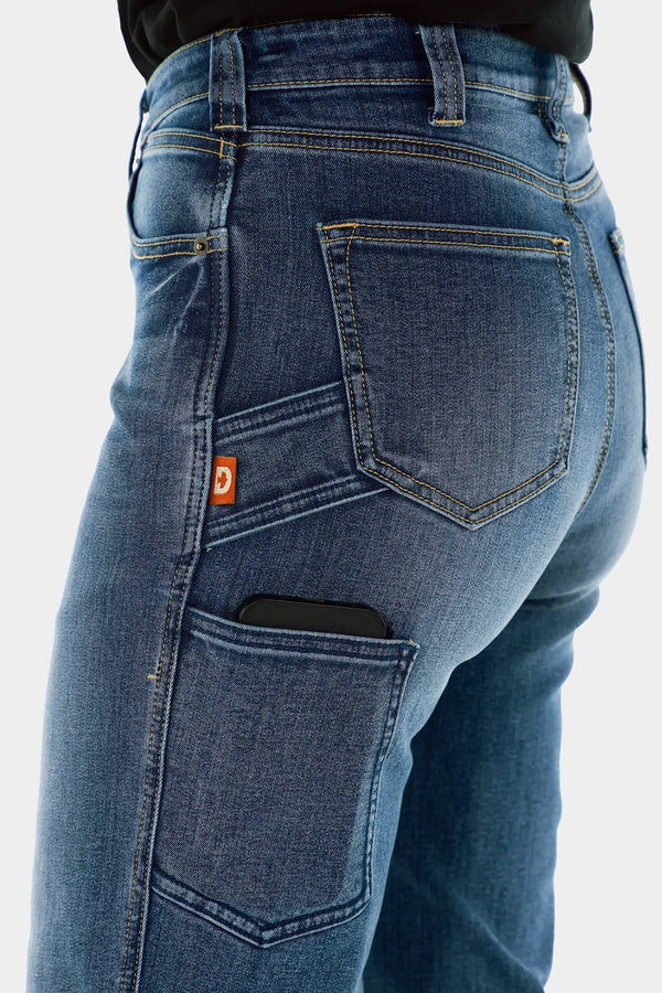 Side view of a woman wearing Dovetail Workwear Old School Wide Leg Jeans in Classic Indigo Blue, showcasing the thigh phone pocket and nested thigh pockets