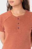 Woman wearing the Terracotta Old School Summer Henley Shirt by Dovetail Workwear, featuring a button-front placket and short sleeves, shown from the front
