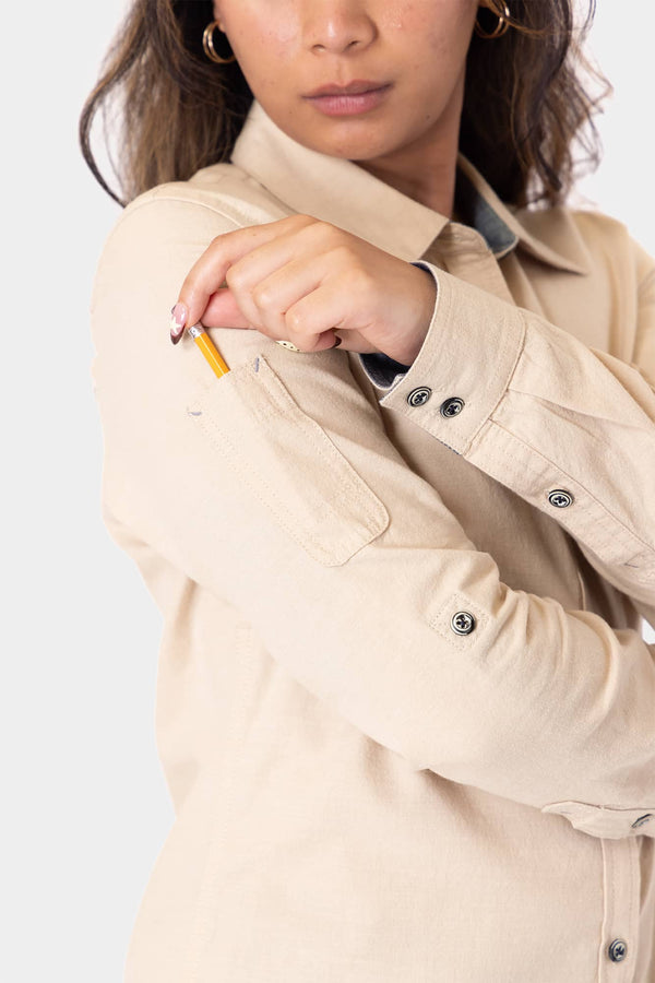 Detail view of the Ecru White Givens Long Sleeve Summer Work Shirt by Dovetail Workwear, showing the pencil pocket on the sleeve and button chest pocket on a woman