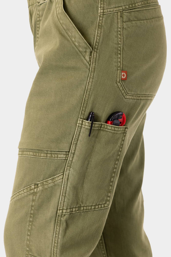 Close-up detail of the Range Crop Pant in Kelp Green by Dovetail Workwear, highlighting the bellowed front pocket with tools and the brand's red label