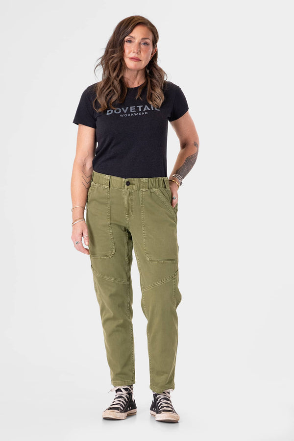 Range Crop Pant in Kelp Green by Dovetail Workwear worn by a woman with a black logo tee and black canvas sneakers, showcasing the relaxed leg fit and bellowed front pockets