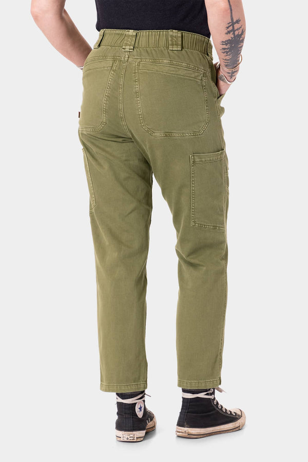 Back view of a woman wearing Dovetail Workwear's Range Crop Pant in Kelp Green, showcasing the bellowed front pockets and relaxed leg cropped silhouette